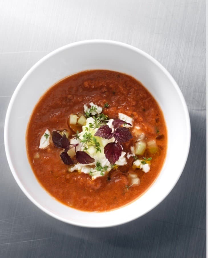 Kyld tomatsoppa serveras med chèvre, olivolja och basilika